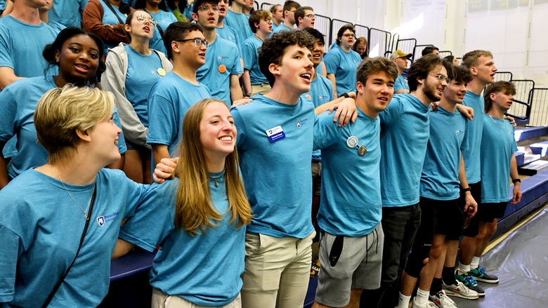 Large group of students stand on risers together.